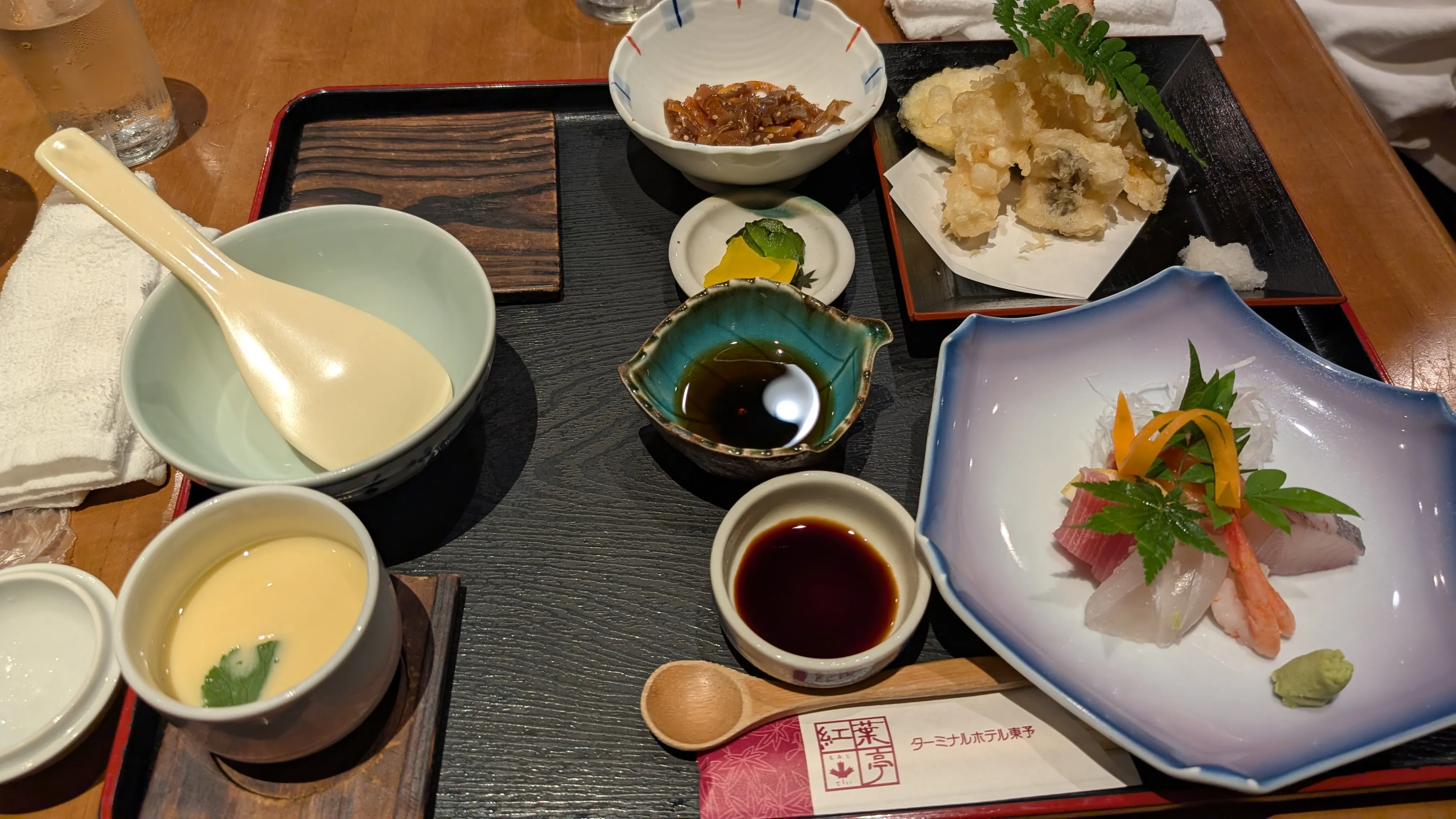 旅館の夕食膳。刺身・天ぷら・茶碗蒸しなどが並んでいる。